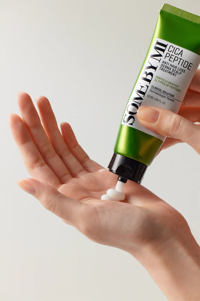 Persona versa sulla mano la maschera trattamento rinforzante per i capelli alla Centella asiatica e peptidi firmata Some by Mi