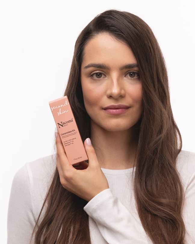 Ragazza che tiene in mano una confezione di siero viso Nacomi Second Skin Ceramides 5% – trattamento rigenerante con ceramidi e peptidi per rinforzare la barriera cutanea e idratare la pelle sensibile
