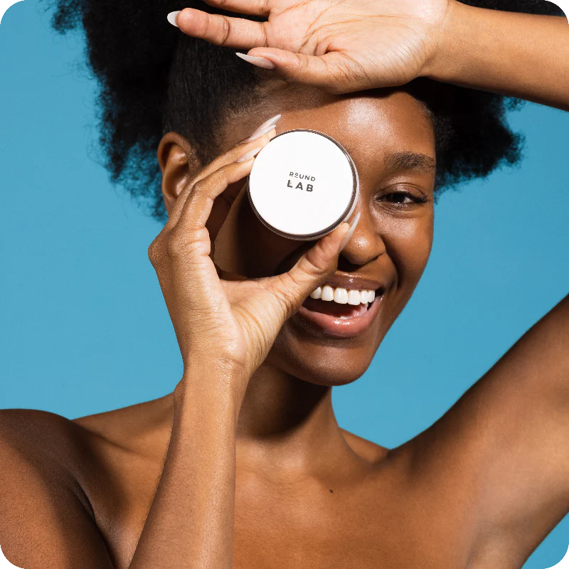 Ragazza sostiene in mano la crema  idratante Round Lab 1025 Dokdo 
